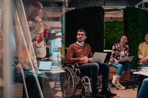 A male employee in a wheelchair in a meeting