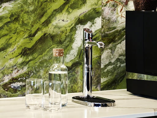 silver HydroTap next to glasses and jug
