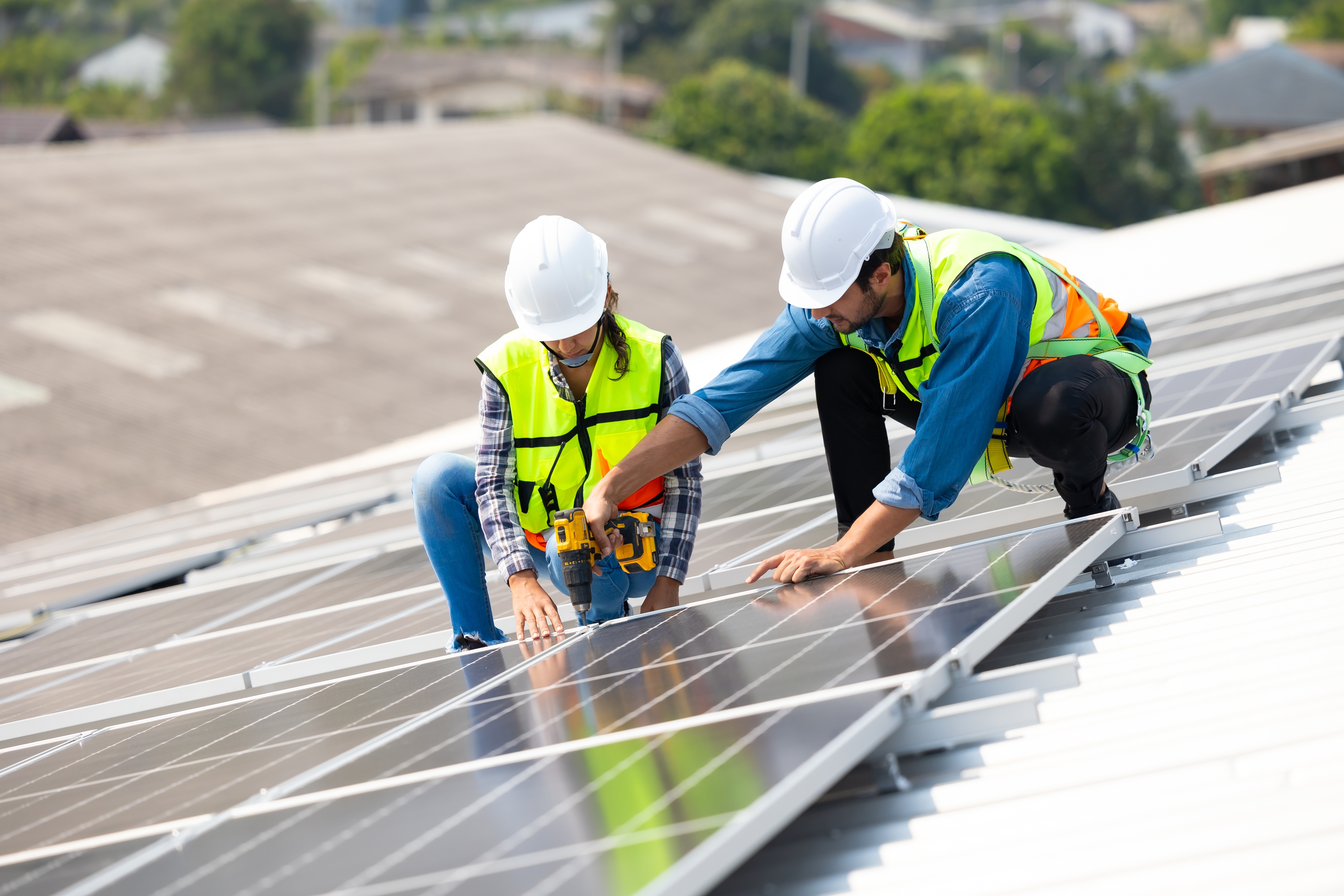 Engineers fitting a new solar panel to an office building in a busy city