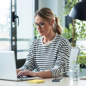 Woman on laptop with glass of water