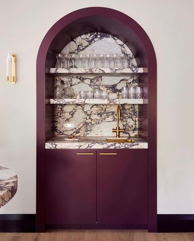  A brushed gold Zip tap against a marbled backsplash design and countertop in a home bar