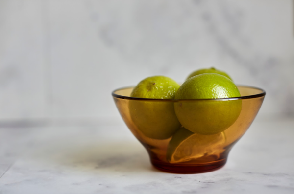 Bowl of limes adds a splash of colour to a marble countertop.