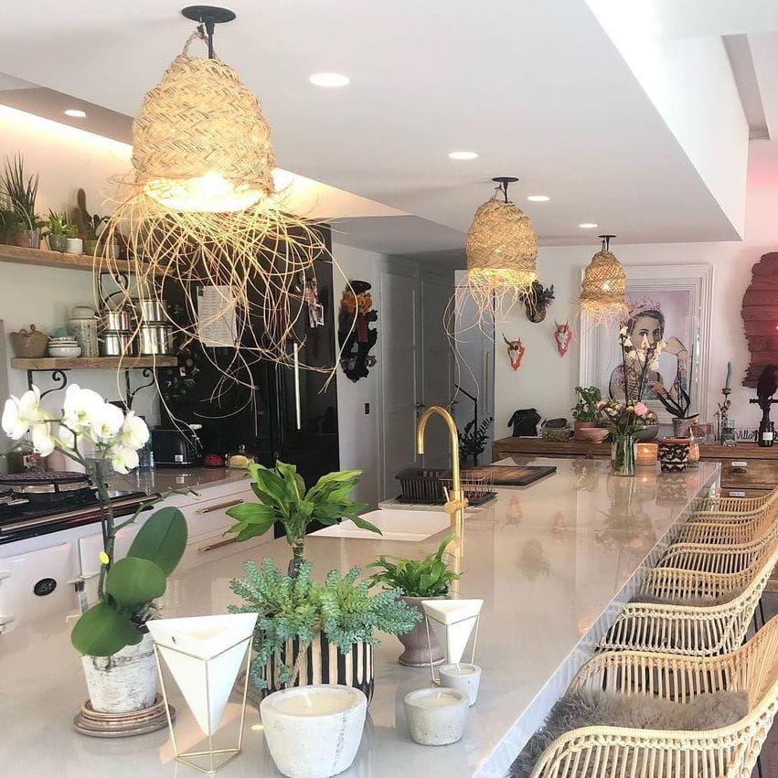A Zip Water tap in a white kitchen with statement lighting and plants